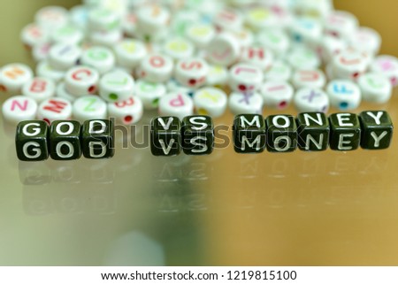 GOD VS MONEY  written with Acrylic Black cube with white Alphabet Beads on the Glass Background