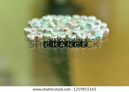 CHANCE written with Acrylic Black cube with white Alphabet Beads on the Glass Background