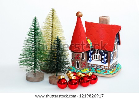 Christmas decorations. Gingerbread house, decorative little trees, red balls and cones