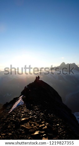 several mountain climbers on the famous Mittellegi Ridge on Eiger mountain in the Alps of Switzerkland heading to the summit at sunrise
