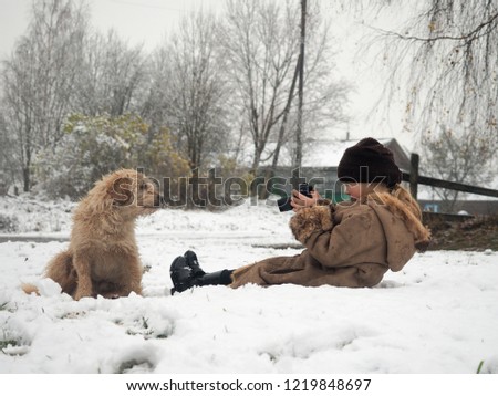 The child takes pictures of the dog. Funny photo shoot of your favorite pet