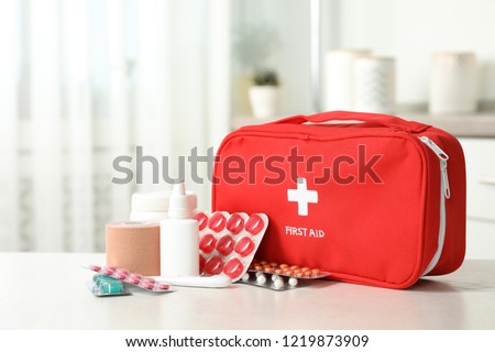 First aid kit with pills on table indoors Royalty-Free Stock Photo #1219873909
