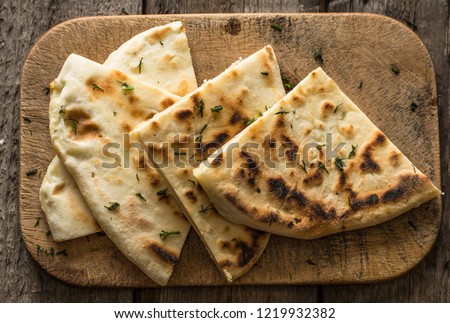 Pita bread on wooden board with feta cheese and tomatoes and pepper. Still life of food. Georgian cuisine. Spanish food. National cuisine. Traditional dish on wooden table. Mediterranean cuisine. Royalty-Free Stock Photo #1219932382