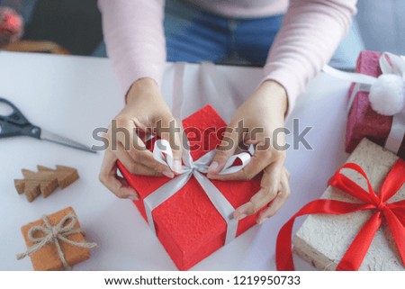asian woman holding red gift box  on the hands offer to you on christmas tree background.