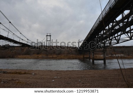 This picture shows an old elevated bridge with a simple metal grid one