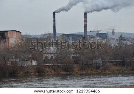 This picture shows two smoking funnels with river foreground