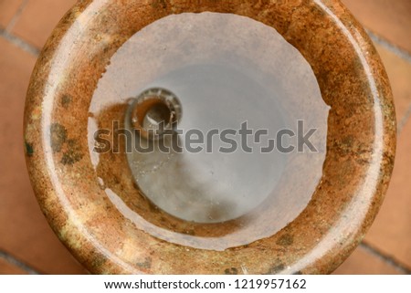 
the edge of a stone vase filled with water