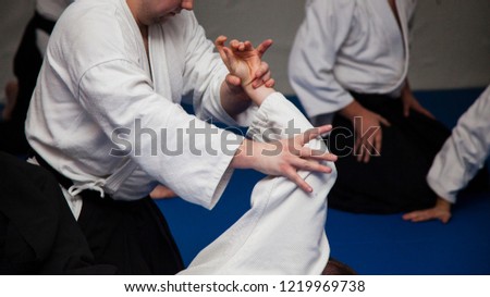 Aikido athletes train in the dojo. Aikidoki work out the elements of aikido equipment Royalty-Free Stock Photo #1219969738