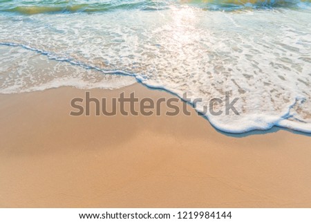 Soft sea waves with bubbles on the beach.