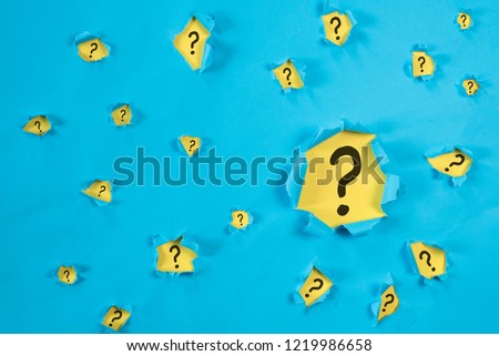 Torn blue paper revealing QUESTION MARK on yellow paper. concept of questions, faq, q&a, problem, riddle and quiz background Royalty-Free Stock Photo #1219986658