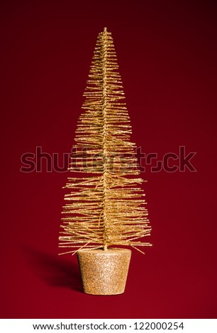 golden toy christmas tree on red
