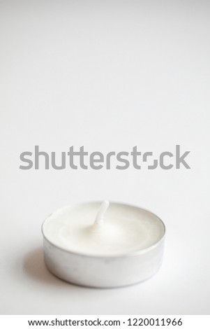 Tea light candles lit with flame on a white background