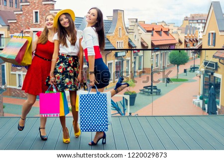 Pretty happy adult women female girls in colorful dresses and high heels with shopping bags walking at street after shopping in shopping mall in hot summer. Shop sales, black Friday tourist concept