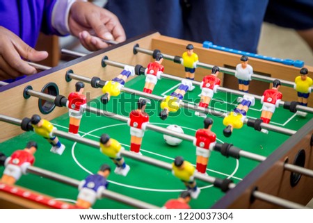 Kick off strike in table football game. Young people playing foosball table game. Royalty-Free Stock Photo #1220037304
