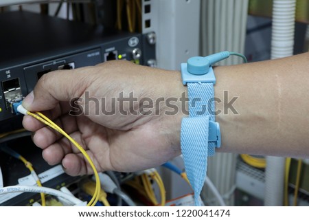 Engineers are checking the electronic board by wearing an antistatic wrist strap.ESD wrist strap is an antistatic device used to safely ground a person working on very sensitive electronic equipment.