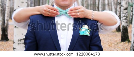 Man the groom in a wedding costume with butterfly. Women's hands holding accessory. Holiday.