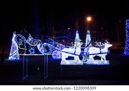 Outdoor decoration reindeer sleigh with blue lights. Christmas reindeer sleigh lights effects