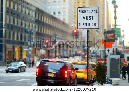 Roadsign in New York. Cars, taxi cabs and people rushing on busy streets of downtown Manhattan. Iconic NYC street views.
