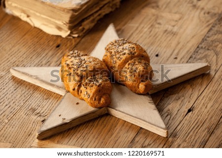 two delicious croissants on a wooden star on a wooden table.rustic style in warm colors photo
