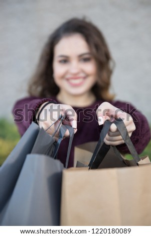 Girl suggesting shopping bags in front of her