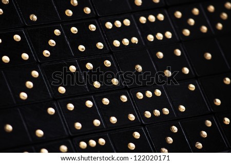 background made of black domini with golden dots  closeup