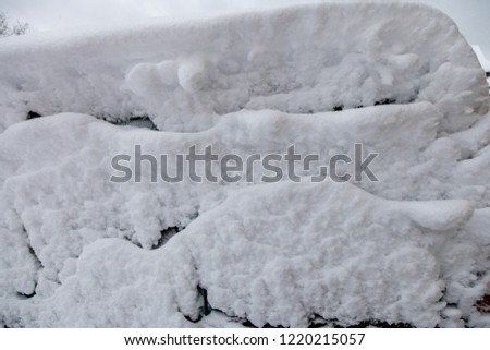 Surface of car is covered with snow after blizzard, natural winter background