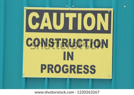 Construction in Progress Sign - on galvanized fence at a construction site - large version