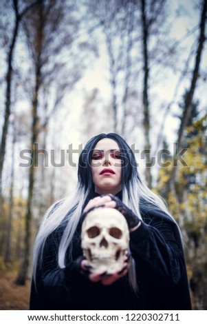 Image of witch woman with skull in hands