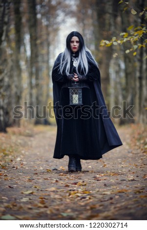 Photo of witch girl with lantern in hands