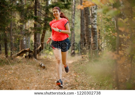 Photo of sports brunette running through park