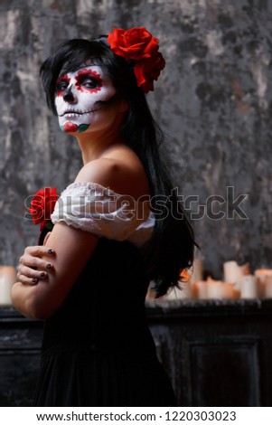 Photo of zombie woman with white face and red flower on her head