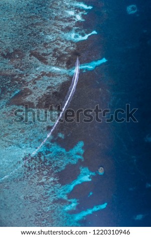 long tail boat sailing through shallow reefs long exposure of blue water and boat wake blue and turquoise with copy space