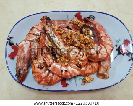 Asian style stir fried tiger prawn  on a traditional plate