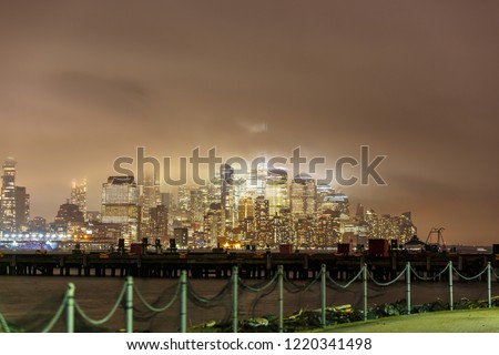 Manhattan skyline during night time, windy and rainy weather. 
