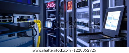 label of fiber optic cable and high speed network router switch in a technology data center room . blur monitor show graph information in background. widescreen Royalty-Free Stock Photo #1220352925