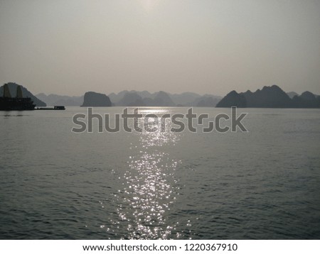 Sunlight shining through the clouds in the cloudy day with the seascape of Halong Bay.