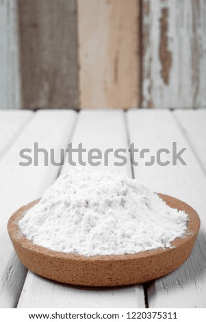 Flour on wooden plate over the white table