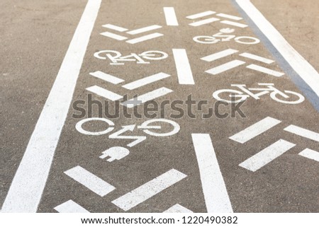 Asphalt road with bicycle and electric transport lane. Cycle and zero emission vehicles white sign on floor. Recreation area for green energy transport in city park