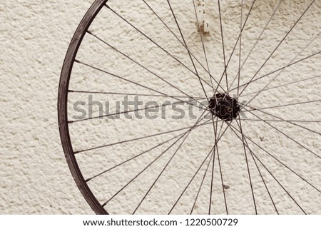 Bicycle wheel hanging outside on a wall