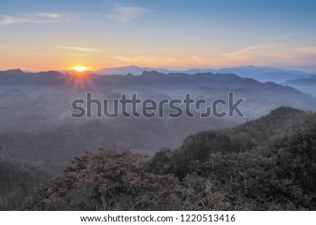 Mountain view misty morning above the village and forest, view of the hill around with the mist with colorful of sun light in the sky background, sunrise at Ban Ja Bo, Pang Mapha, Mae Hong Son