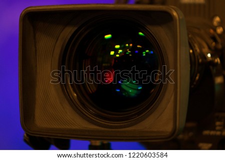 Close-up of a Television Camera lens in a blue screen studio environment.
