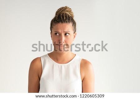 Afraid pretty Latin girl looking aside and pressing lips. Portrait of young Hispanic woman waiting for trouble. Anticipating failure concept