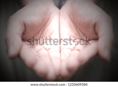 Outstretched cupped hands together of woman - isolated on black background
