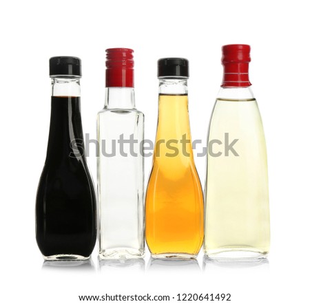 Bottles with different kinds of vinegar on white background Royalty-Free Stock Photo #1220641492