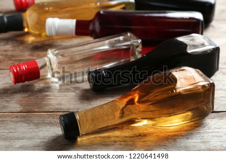 Bottles with different kinds of vinegar on wooden table Royalty-Free Stock Photo #1220641498