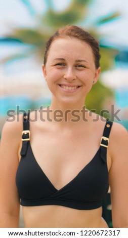 Girl smiling on the beach in a bathing suit, the sun, warmth and palm trees around