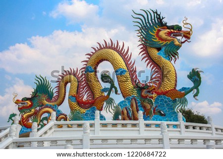 colorful Chinese dragon statue in public park with blue sky background
