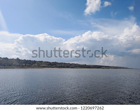 Seascape Sea with calm water and white clouds