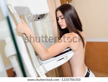 cute young girl on the examination of the breast using the mammography x ray machine, which carry out examination of the breast . Prevention of breast cancer