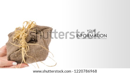 Female hand holding a gift wrapped in a sackcloth pattern on a white background isolation